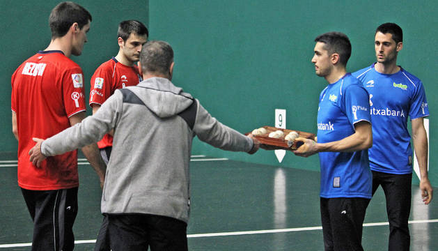 El seleccionador Martín Alustiza entrega a Víctor la caja con las seis pelotas que se pusieron en juego en el Labrit
