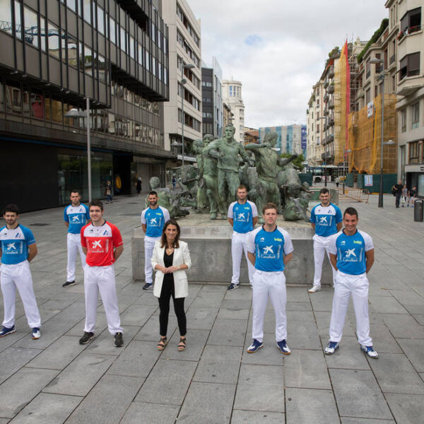 Diez de los participantes en el torneo Masters e Isabel Moreno, directora territorial de CaixaBank, posan delante del monumento al Encierro.