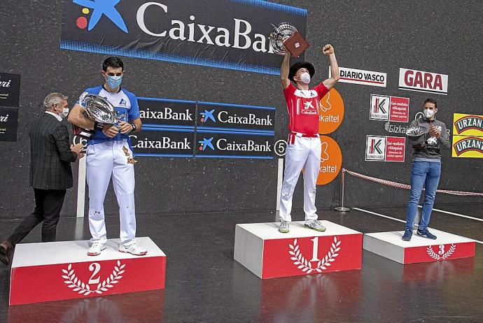 Erik Jaka, con la txapela que le acredita como ganador del Manomanista, celebra la victoria en el podio junto a Jokin Altuna, subcampeón, y Darío Gómez, tercero